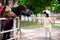 Cute Asian girl touring the zoo. Kid was feeding a carrot to a horse standing in a white stable.