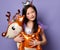 Cute asian kid girl in party dress and crown and with painted red hearts is holding a toy deer air balloon