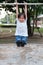 Cute Asian kid hanging on pull-up bar at playground in the village park. Sport outdoor activity for kid