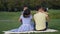 Cute asian kids tenderly embracing parents in park