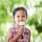 Cute asian little child girl is eating delicious icecream cone