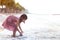 Cute asian little child girl having fun to play on beach