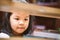 Cute asian little girl is finding a book on bookshelf