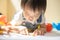 Cute asian little girl is painting the color with fully happiness moment , concept of art and education for kid.toddler girl