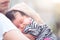 Cute asian newborn baby girl sleeping on mother`s chest