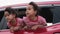 Cute Asian siblings girls smiling and having fun traveling by car and looking out of the car window. Happy family enjoying road tr