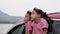 Cute Asian siblings girls smiling and having fun traveling by car and looking out of the car window. Happy family enjoying road tr