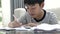 Cute asian teen boy doing your homework at home.