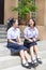 Cute Asian Thai high schoolgirls student couple happy chatting