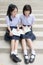 Cute Asian Thai high schoolgirls student couple reading