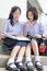 Cute Asian Thai high schoolgirls student couple reading in school