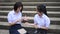 Cute Asian Thai high schoolgirls student couple in school uniform are having fun playing `rock-paper-scissors` with her student fr