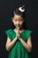 Cute Asian woman praying for Christmas with headdress on black background and gathering two hands Children