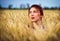 Cute attractive young girl on wheat field during sunset. Pensive look. Romantic atmosphere