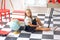 Cute Ñaucasian girl in a white blouse and black pleated skirt sitting in a school interior