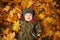 Cute Autumn Child on Fall Yellow Leaves