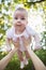 Cute baby with beautiful large eyes on the nature background.  Motherhood, parenthood, people and happy family concept. Mother