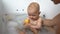 A cute baby boy in a bathtub playing with a duck toy