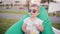 Cute baby boy in a big funny sunglasses sitting in bean bag chair at the park in summer day. Holding a glass with straws