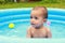 Cute baby boy in blue inflating pool
