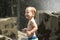 Cute baby boy on the fountain and waterfall and stones background