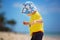 Cute baby boy playing with beach toys on tropical beach