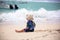 Cute baby boy playing with beach toys on tropical beach