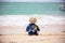 Cute baby boy playing with beach toys on tropical beach