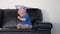 Cute baby boy playing with documents papers on sofa