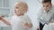 Cute baby boy playing tinsel in living room. Closeup serious small kid.