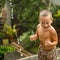 Cute baby boy playing under the rain