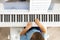 Cute baby boy playing white electrical forte piano pressing keys kid studying at musical school