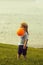 Cute baby boy plays with orange toy balloon