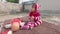 Cute baby boy in red woolen winter clothing with bottle looking wonder. Kid sitting on carpet on the roof at home in sunlight.