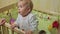 Cute baby boy standing in crib