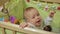 Cute baby boy standing in crib