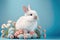 Cute baby bunny with flowers on blue background. Cute fluffy rabbit. Animal Easter symbol concept. Generative AI