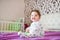 Cute baby, close up. Portrait of a crawling baby on the bed in her room