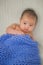 Cute baby covered in blue towel quilt making various expressions