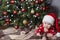 Cute baby crawls under the Christmas tree at home.