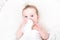 Cute baby drinking milk from a bottle in a white crib