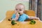 Cute baby eating broccoli