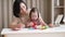 Cute baby girl with down syndrome learning with educational toys at home with mom,child special education in the family