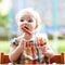 Cute baby girl eating sausage from fork