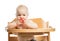 Cute baby girl eating tomato while sitting in high chair