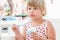 Cute baby girl eats yogurt with ice cream and fruits