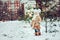 Cute baby girl enjoying winter walk in snowy park, wearing warm hat