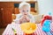 Cute baby girl feeding herself with finger food in the kitchen