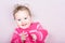 Cute baby girl in a pink knitted sweater with hearts pattern