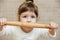 Cute baby girl is preparing in kitchen. Funny little girl is having fun with rolling pin for dough